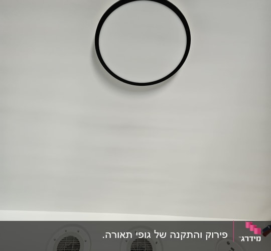 תמונה של תקרה עם פתחי אוורור ועיגול תאורה